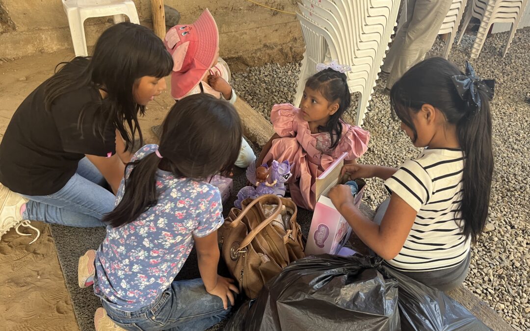 Donor observing local staff serve food to children at a modest feeding center in Honduras, natural light through open windows.